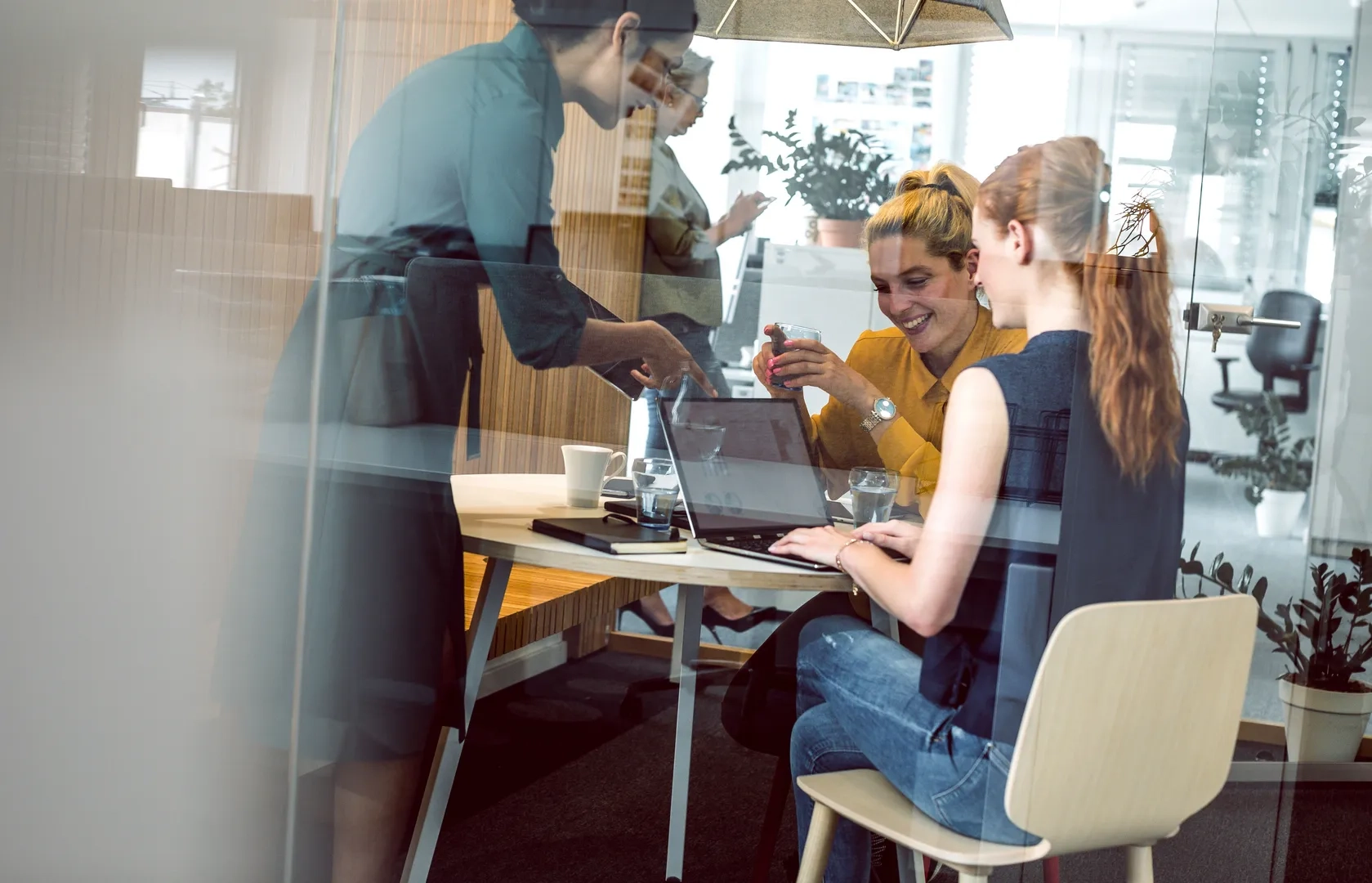 Arbeitsgruppe, lachend am Schreibtisch